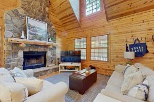 a living room with a stone fireplace in a cabin at Kingfisher Cove Cabin 19 in Saugatuck