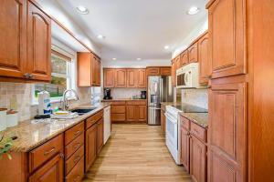 a large kitchen with wooden cabinets and white appliances at Gathering Place in Frankfort