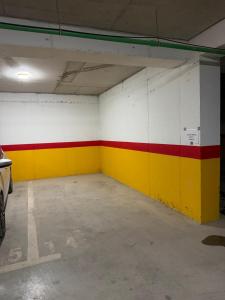 an empty garage with red yellow and white walls at OMA Residence in Ferizaj