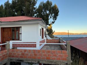 a small house on the shore of a body of water at Qocha Simi Homestay in Ocosuyo