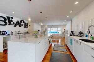 a large kitchen with white cabinets and a large island at Downtown Hideaway in New Buffalo