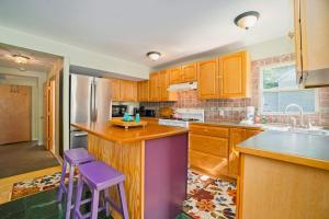 a kitchen with wooden cabinets and purple stools at Carol's Cottage in Empire +17 photos