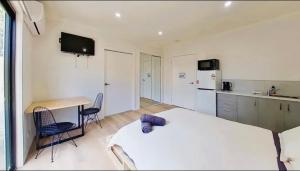 a bedroom with a bed and a desk and a kitchen at Seymour Studios in Seymour