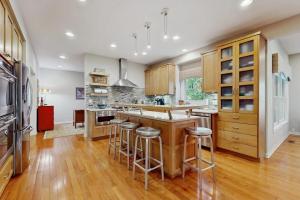 a kitchen with wooden cabinets and bar stools at Grand Getaway in Grand Beach