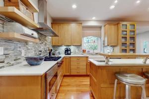 a kitchen with wooden cabinets and a counter top at Grand Getaway in Grand Beach +17 photos