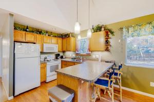 a kitchen with a white refrigerator and wooden cabinets at Uncle Warren's Retreat in Glen Arbor +9 photos