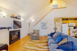 a living room with a blue couch and a fireplace at Uncle Warren's Retreat in Glen Arbor