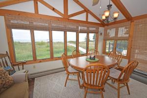 a dining room with a table and chairs and windows at Ships Haven in Glen Arbor