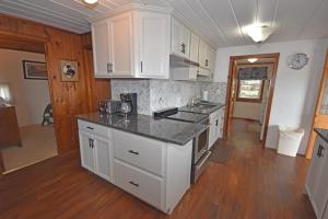 a kitchen with white cabinets and a black counter top at Ships Haven in Glen Arbor