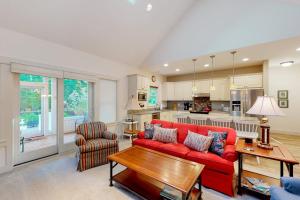 a living room with a red couch and a kitchen at Cardinal Corner in Glen Arbor