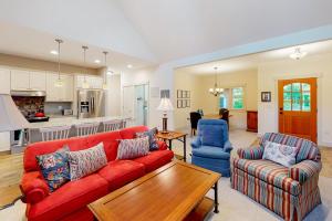 a living room with a red couch and a table at Cardinal Corner in Glen Arbor