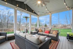 a screened in porch with couches and chairs on a deck at Hidden Serenity in Sawyer
