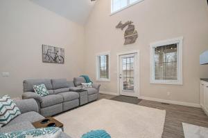 a living room with a gray couch and windows at Hidden Serenity in Sawyer