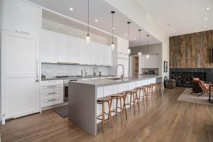 a kitchen with white cabinets and a bar with bar stools at Leisure On The Lake in New Buffalo
