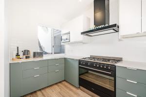 a kitchen with gray cabinets and a stove top oven at Abby’s Beach Villa in Broadwater