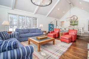 a living room with blue couches and red chairs at Point Cottage at Point O' Woods in Benton Harbor