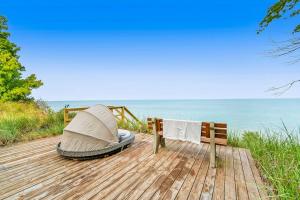 a boat sitting on a wooden deck next to the ocean at Dune House in Manistee