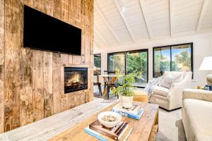 a living room with a fireplace and a tv on a wall at Dune House in Manistee