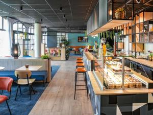 a restaurant with a bakery counter with pastries at Hôtel Ibis Vitré Centre Ville climatisé in Vitré