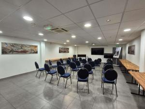 a conference room with chairs and a podium and a screen at Mercure Périgueux Centre Historique in Périgueux