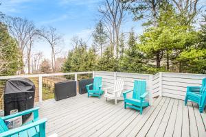 a deck with three chairs and a grill on it at The Gatehouse on Orchard Beach in Lakeside