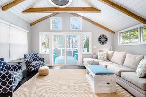 a living room with a couch and chairs and a clock at The Gatehouse on Orchard Beach in Lakeside