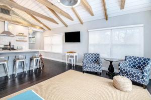 a living room with a kitchen and a table and chairs at The Gatehouse on Orchard Beach in Lakeside +28 photos