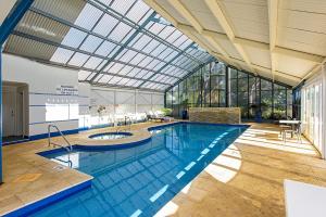 a large swimming pool with a glass ceiling at Abby’s Beach Villa in Broadwater