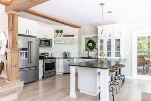 a kitchen with white cabinets and stainless steel appliances at Mac's Bluff in Grand Beach
