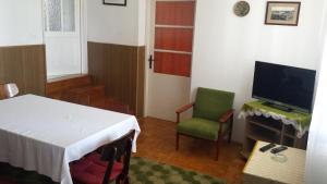 a room with a table and a television and a chair at Apartment Jasenka in Krk