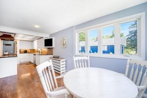 a kitchen and dining room with a white table and chairs at Harbor Charm in Harbor Springs