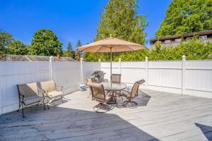 a patio with a table and chairs and an umbrella at Harbor Charm in Harbor Springs