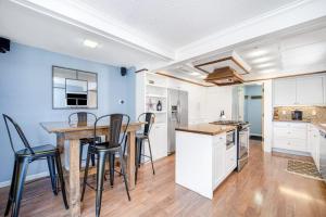 a kitchen with white cabinets and a wooden table and chairs at Harbor Charm in Harbor Springs