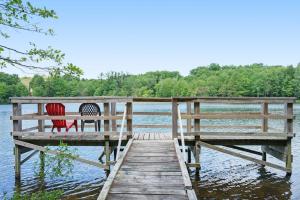 two chairs sitting on a dock on a lake at Beach House in Saugatuck