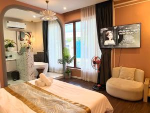 a bedroom with a bed and a flat screen tv at Romance Hotel in Ho Chi Minh City