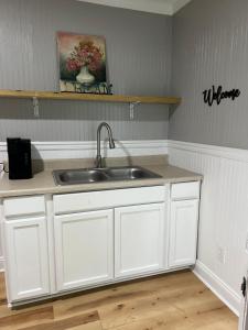 a kitchen with white cabinets and a sink at Brooklyn's Tiny Apartment Pets Welcome in North Little Rock