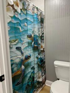 a bathroom with a shower curtain with two sea turtles at Brooklyn's Tiny Apartment Pets Welcome in North Little Rock +2 photos