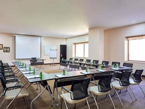 a conference room with tables and chairs and a whiteboard at ibis Amman in Amman