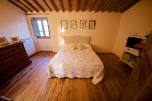 1 dormitorio con 1 cama y suelo de madera en Villa Anna, en Colle Val D'Elsa