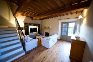 una sala de estar con 2 sofás blancos y una escalera en Villa Anna, en Colle Val D'Elsa