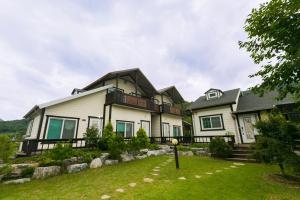 a large white house with a fence in the yard at danyang deulggochyanggi in Danyang