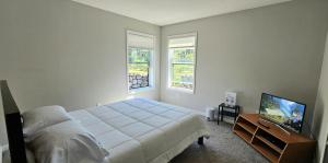 a bedroom with a bed and a flat screen tv at River Valley Stay in Eagan
