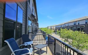 a balcony with two chairs and a table on it at River Valley Stay in Eagan