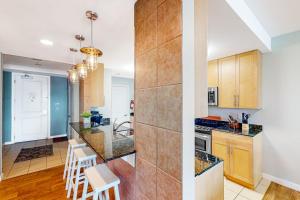 a kitchen with wooden cabinets and a counter top at The Sanctuary - Summer Breeze A114 in Virginia Beach