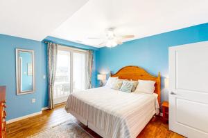 a blue bedroom with a bed and a ceiling fan at The Sanctuary - Summer Breeze A114 in Virginia Beach