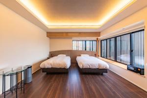 two beds in a room with a large window at 貞芙庵 in Ichinomiya +62 photos