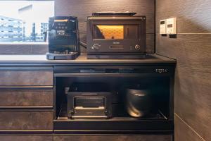 a kitchen with a microwave and a toaster oven at 貞芙庵 in Ichinomiya