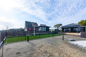 a house with a fence in front of a yard at 貞芙庵 in Ichinomiya