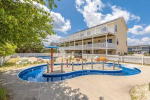 a large building with a swimming pool and a resort at Down By The Sea in Virginia Beach