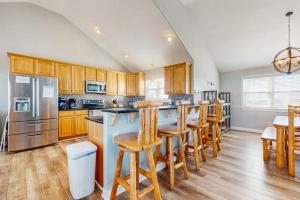a kitchen with wooden cabinets and a island with bar stools at Down By The Sea in Virginia Beach +38 photos